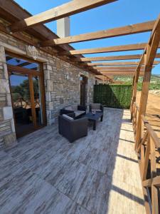 a patio with a wooden pergola at Alyki Stone Houses 1 in Alyki