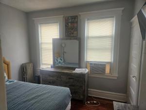 a bedroom with a dresser with a mirror and a bed at Hillside Appartment #2 in Newark