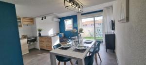 a kitchen with a table and chairs in a room at L'Ophelia Duplex Dernier étage balcon Centre climatisation in Sète +4 photos