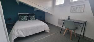 a bedroom with a bed and a desk and a chair at L'Ophelia Duplex Dernier étage balcon Centre climatisation in Sète