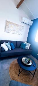 a living room with a blue couch and a table at L'Ophelia Duplex Dernier étage balcon Centre climatisation in Sète