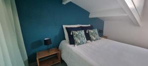 a bedroom with a white bed with a blue wall at L'Ophelia Duplex Dernier étage balcon Centre climatisation in Sète