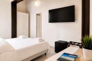 a bedroom with two beds and a flat screen tv at Torrearsa 17 in Trapani