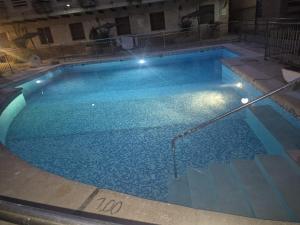 a large swimming pool with blue water at night at ESCAPADA RELAX in Arroyo Frio