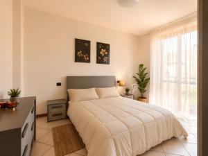a bedroom with a bed and a desk and a window at La Terrazza delle Colline in Brunello