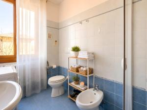 a blue and white bathroom with a toilet and a sink at La Terrazza delle Colline in Brunello +29 photos