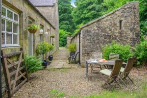 a garden with a table and chairs and a building at 2 Bed in Hexham oc-88032 in Bardon Mill