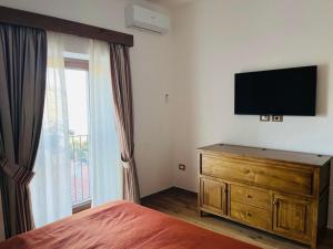 a bedroom with a bed and a television on a wall at Borgo Izzo 2 in San Fele