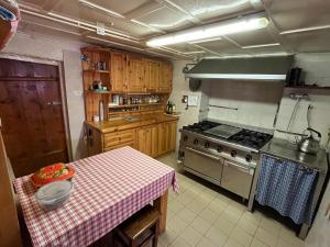 a kitchen with a table and a stove top oven at Baita Pòz in Valfurva +70 photos