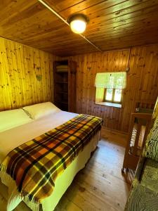 a bedroom with a bed in a wooden cabin at Baita Pòz in Valfurva