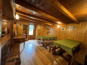 two tables in a room with wooden walls at Baita Pòz in Valfurva