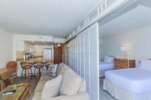 a bedroom with a bed and a living room at Ilikai Tower 1403 in Honolulu