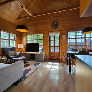 a living room with a television and a table and chairs at Akureyri Cottages in Akureyri
