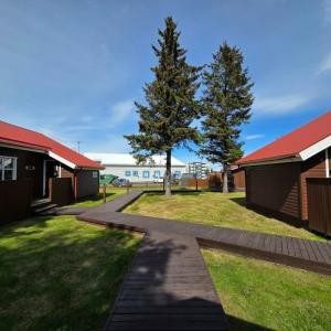 a walkway between two buildings with a tree in the middle at Akureyri Cottages in Akureyri