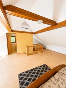 an attic room with a bed and a wooden floor at Digital Detox House Haloze in Podlehnik