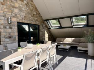 a room with a table and chairs and a couch at Loft de prestige au pied du circuit in Francorchamps