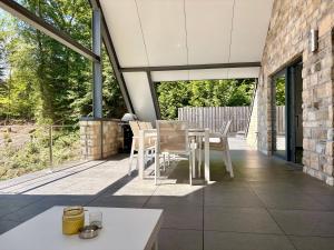 a patio with a white table and chairs on it at Loft de prestige au pied du circuit in Francorchamps