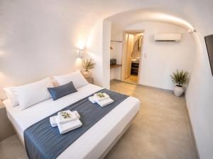 a bedroom with a large white bed with towels on it at Fira Centrum White in Fira
