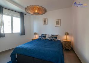 a bedroom with a blue bed and two lamps at Olydea Beausoleil in Beausoleil