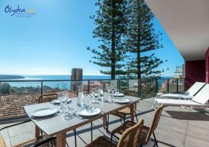 a table on a balcony with a view of the ocean at Olydea Beausoleil in Beausoleil