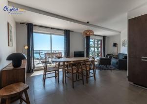 a dining room and living room with a table and chairs at Olydea Beausoleil in Beausoleil