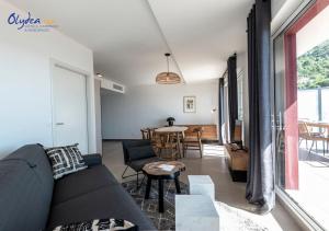 a living room with a couch and a table at Olydea Beausoleil in Beausoleil