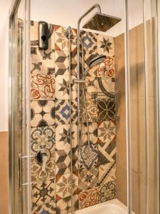 a shower in a bathroom with a mosaic wall at Torrearsa 17 in Trapani +44 photos