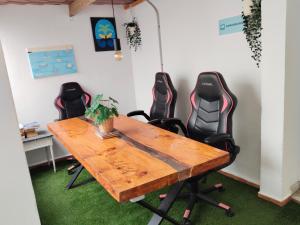 a conference room with a wooden table and four chairs at Puerto Nest Hostel in Puerto de la Cruz