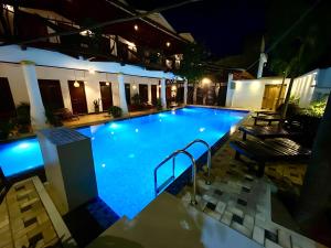 a large swimming pool at night with lights at Oasis Bay - Arugam Bay in Arugam Bay