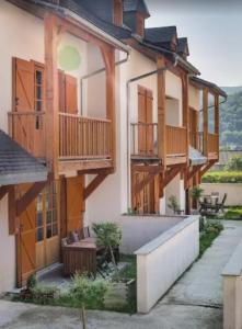 a house with wooden balconies and a patio at Résidence Vignec Village by Actisource in Vignec