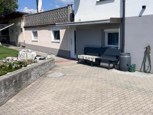 a patio with a bench next to a house at Unterkunft LUSCHIN in Spielberg