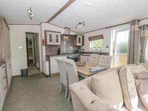 a kitchen and living room with a table and chairs at 2-Bed Cabin - Sleeps 5 - Parking - Pet Friendly in Carnforth