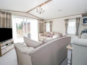 a living room with a couch and a tv at 2-Bed Cabin - Sleeps 5 - Parking - Pet Friendly in Carnforth
