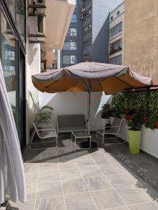 a patio with an umbrella and chairs on a balcony at Tanger City 6 in Tangier