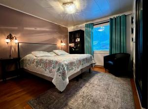 a bedroom with a bed and a chair and a window at Villa Aurora in Rovaniemi