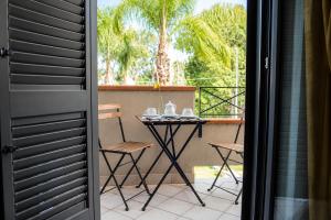 a balcony with a table and chairs on a balcony at Oasi Park Hotel in Mascali