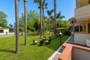 a park with palm trees and a building at Oasi Park Hotel in Mascali