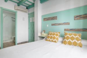 a bedroom with a white bed with two pillows at Hostal Santa Catalina in Conil de la Frontera