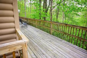 a wooden deck with a bench sitting on it at Tree-Top Chalet in Logan