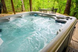 a jacuzzi tub with a table and chairs in it at Tree-Top Chalet in Logan