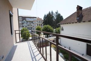 a balcony with a wooden railing in a building at Apartament Ultracentral NICOL in Curtea de Argeş