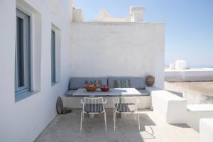 a patio with a blue bench and two chairs at DYO Tinos in Triandáros