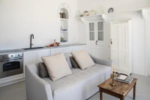a white living room with a couch and a table at DYO Tinos in Triandáros +18 photos