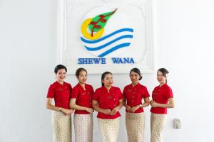 a group of girls in red shirts standing in front of a sign at Shewe Wana Boutique Hotel in Chiang Mai
