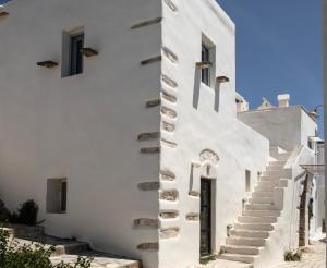 a white building with stairs on the side at DYO Tinos in Triandáros