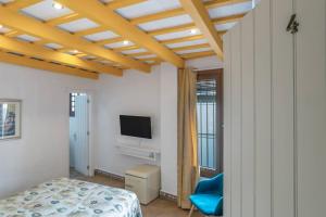 a bedroom with a bed and a flat screen tv at Hostal Santa Catalina in Conil de la Frontera