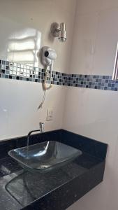 a bathroom with a sink and a phone on the wall at Casa confort - Vicente pires in Brasília