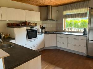 a kitchen with white cabinets and a large window at Forest nine Villa Apartments in Kuusalu