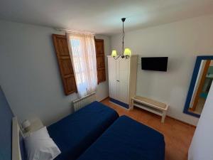 a bedroom with a blue bed and a tv at Casa Rural Tronchon in Tronchón