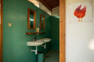 a green bathroom with two sinks and a chicken on the wall at Bikers camp in Poreč +50 photos